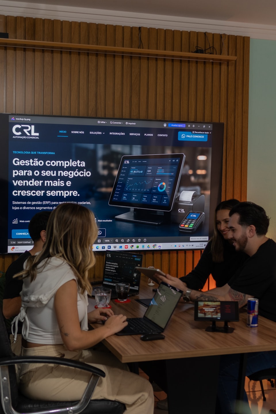 Team reviewing CRL Automação Comercial ERP system on laptops and tablet.